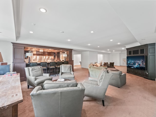 living area featuring light carpet, ornamental molding, recessed lighting, a warm lit fireplace, and bar