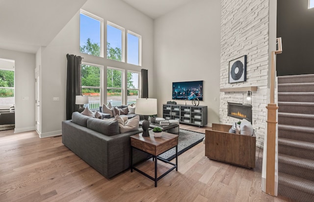 6232 Marsh, Ypsilanti, MI 48197 - living room with a towering ceiling, light wood-style floors, stairway, baseboards, and a stone fireplace
