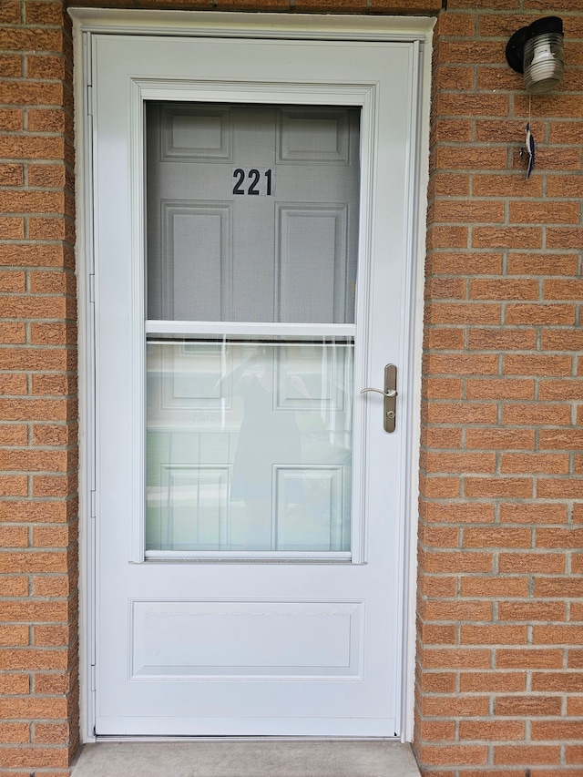 view of exterior entry featuring brick siding