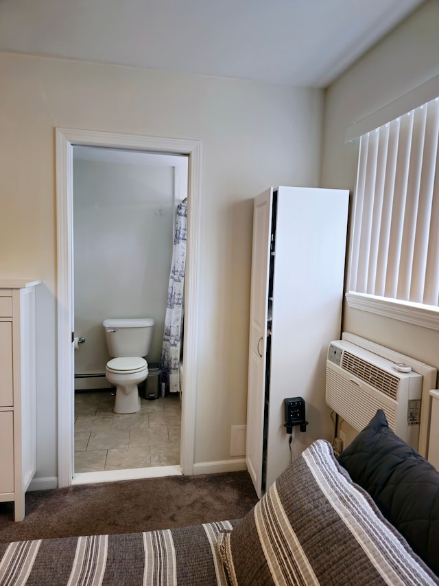 bedroom featuring an AC wall unit, carpet floors, baseboard heating, and baseboards