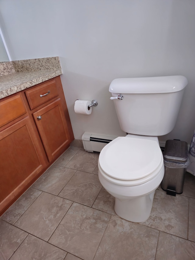 half bath featuring a baseboard radiator, vanity, and toilet