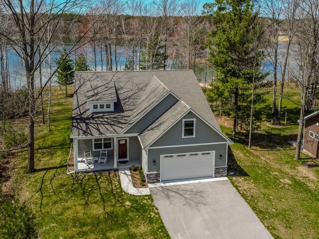 153 Tippi Trl, Buckley, MI 49620 - view of front of property with asphalt driveway, a porch, stone siding, a front lawn, and a garage
