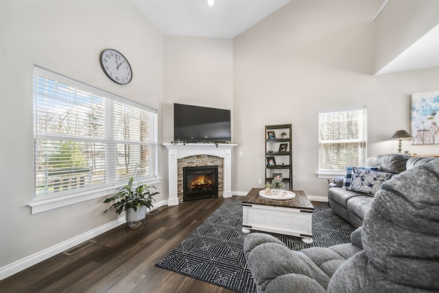 153 Tippi Trl, Buckley, MI 49620 - living room with high vaulted ceiling, baseboards, wood finished floors, and a stone fireplace