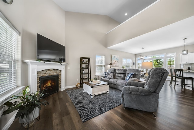 153 Tippi Trl, Buckley, MI 49620 - living area with a stone fireplace, dark wood finished floors, vaulted ceiling, and baseboards