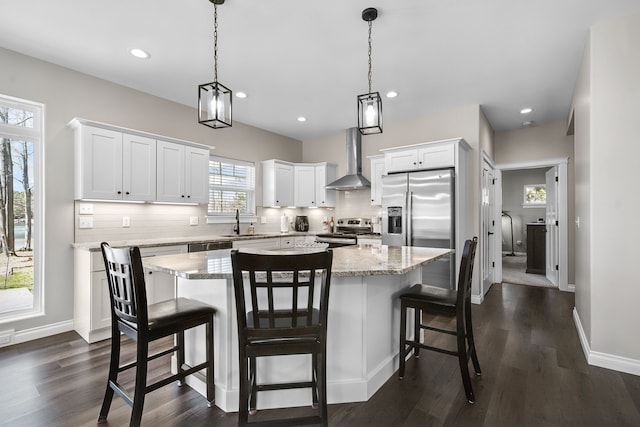153 Tippi Trl, Buckley, MI 49620 - kitchen featuring stainless steel appliances, wall chimney range hood, a sink, decorative backsplash, and white cabinets