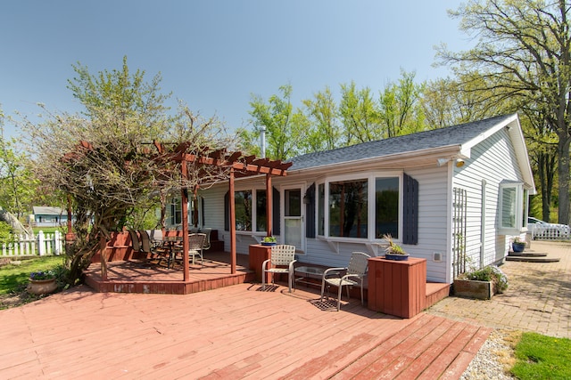 5303 Lake Rd, Reading, MI 49274 - back of property featuring a wooden deck, outdoor dining area, fence, a pergola, and a shingled roof