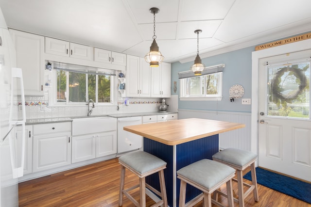 5303 Lake Rd, Reading, MI 49274 - kitchen with white dishwasher, a sink, wooden counters, wood finished floors, and a breakfast bar area