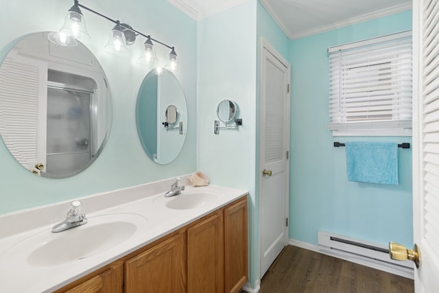 5303 Lake Rd, Reading, MI 49274 - full bathroom with baseboard heating, wood finished floors, crown molding, double vanity, and a shower with shower door