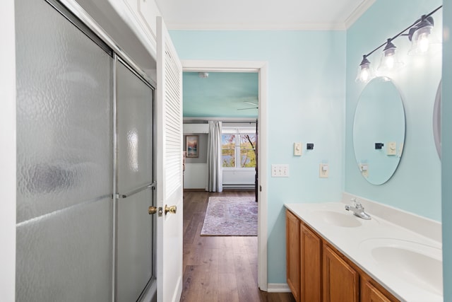 5303 Lake Rd, Reading, MI 49274 - bathroom with wood finished floors, a stall shower, crown molding, double vanity, and a ceiling fan
