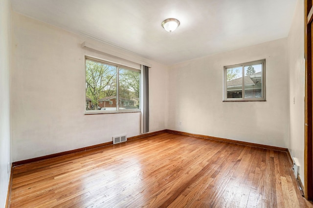 spare room with light wood finished floors and baseboards