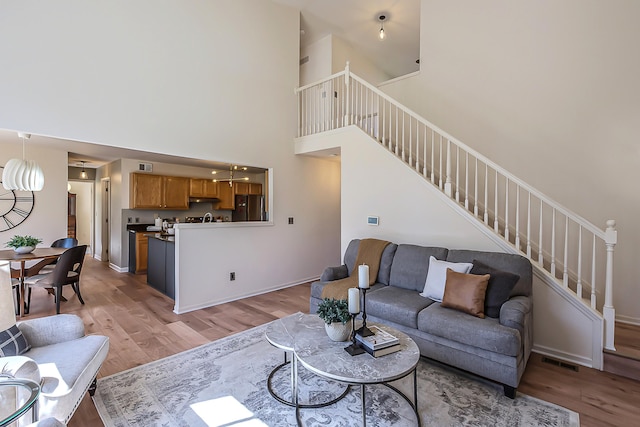 1953 Harley Ct, Ann Arbor, MI 48103 - living area featuring light wood-style flooring, stairway, a high ceiling, and baseboards