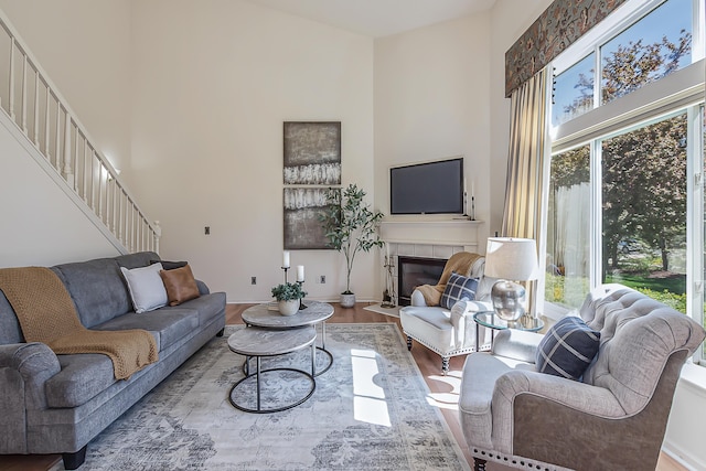 1953 Harley Ct, Ann Arbor, MI 48103 - living room featuring healthy amount of natural light, a towering ceiling, stairs, wood finished floors, and a fireplace