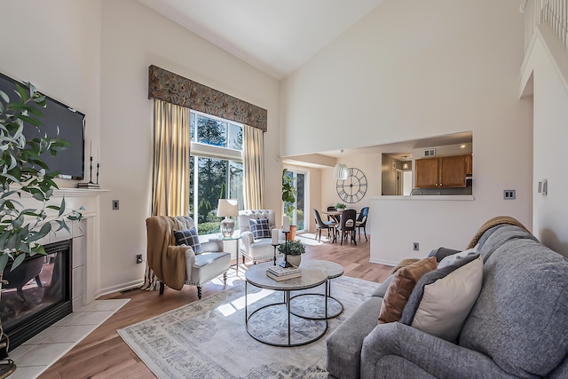 1953 Harley Ct, Ann Arbor, MI 48103 - living room featuring high vaulted ceiling, a tile fireplace, and light wood-style floors