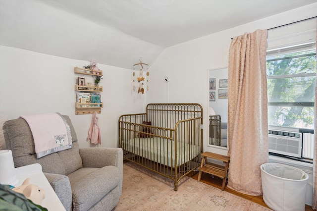 1000 W Ganson St, Jackson, MI 49202 - bedroom featuring wood finished floors, vaulted ceiling, cooling unit, and a crib