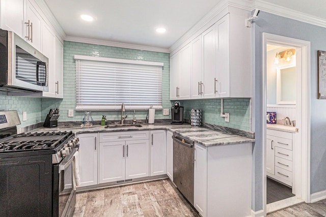 7262 Hatchery Rd, Waterford, MI 48327 - kitchen featuring appliances with stainless steel finishes, a sink, crown molding, light wood-type flooring, and white cabinets