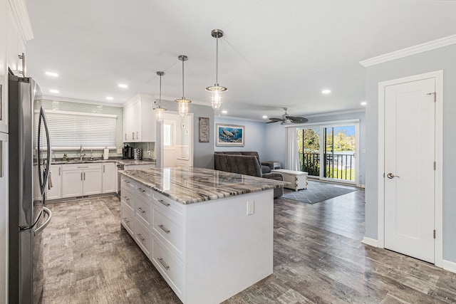 7262 Hatchery Rd, Waterford, MI 48327 - kitchen featuring freestanding refrigerator, open floor plan, wood finished floors, a center island, and ornamental molding