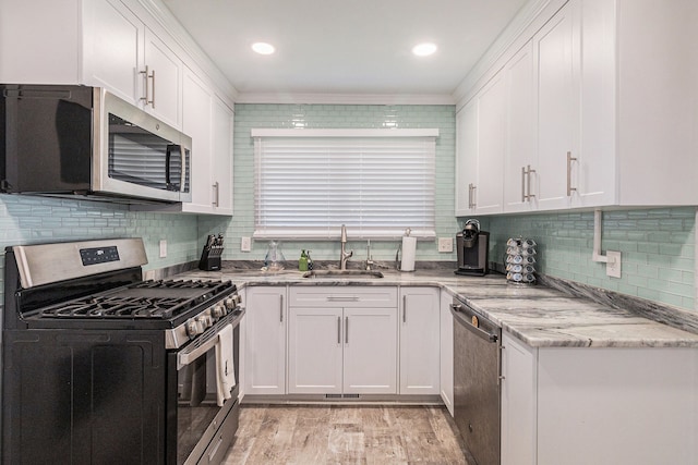 7262 Hatchery Rd, Waterford, MI 48327 - kitchen with stainless steel appliances, a sink, white cabinetry, light stone countertops, and light wood-style floors