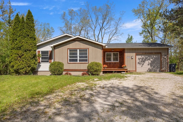 view of front of house with an attached garage, driveway, and a front lawn
