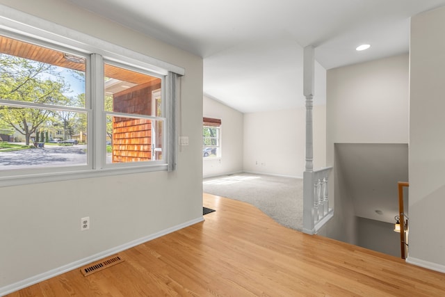 unfurnished room with baseboards, lofted ceiling, and wood finished floors
