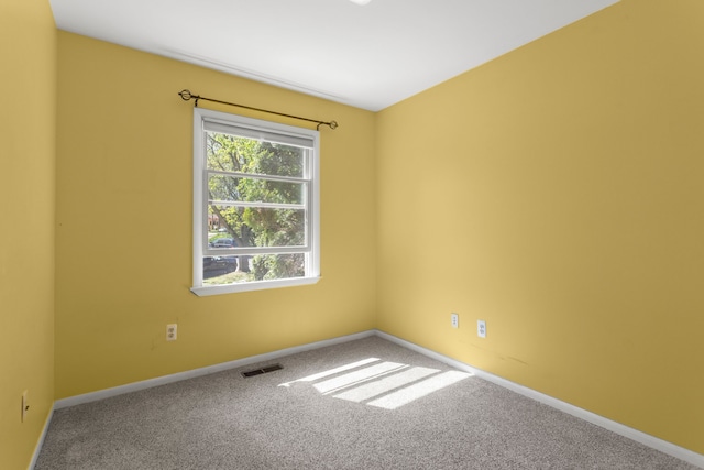 unfurnished room with carpet and baseboards