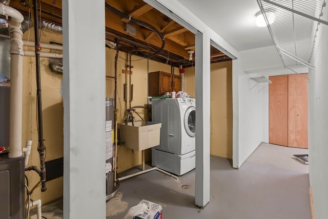 unfinished basement featuring a sink, washer and clothes dryer, and water heater