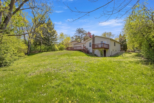 view of green lawn with a wooden deck