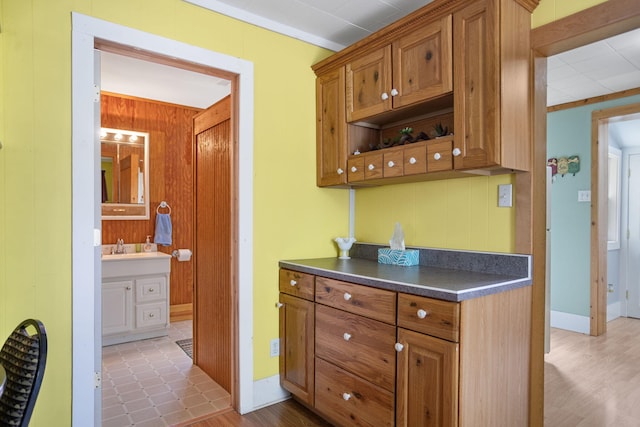 68687 M-43, South Haven, MI 49090 - kitchen featuring dark countertops, brown cabinets, wood walls, and wood finished floors