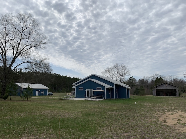view of green lawn with an outdoor structure and an outbuilding