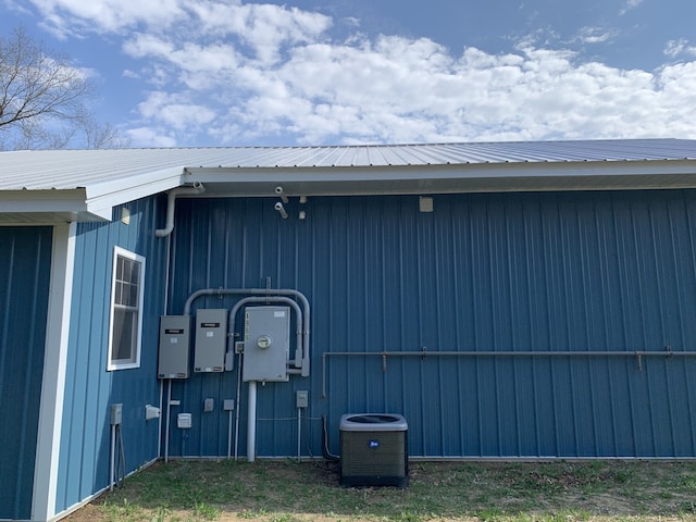 view of side of property with central air condition unit and metal roof