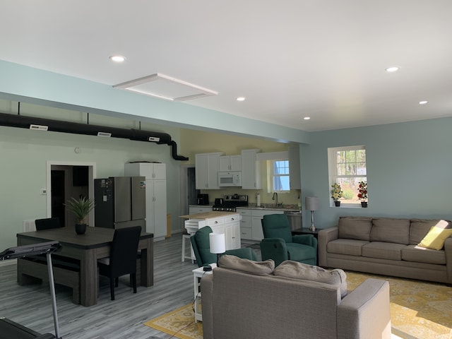living room with light wood-type flooring and recessed lighting