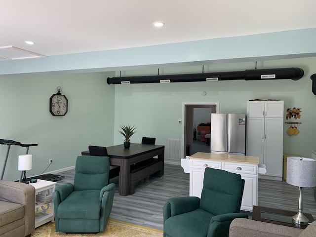 living room with wood finished floors, baseboards, and recessed lighting
