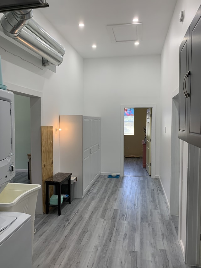 hallway featuring attic access, light wood-style floors, and recessed lighting