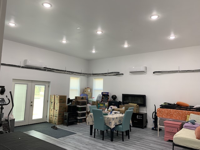 dining space with a wall mounted air conditioner, plenty of natural light, wood finished floors, french doors, and recessed lighting