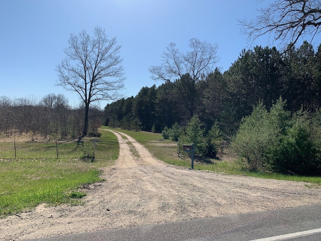 view of dirt / gravel road with a forest view