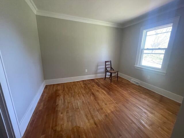 519 Whaley St, Cadillac, MI 49601 - unfurnished room featuring wood finished floors, ornamental molding, and baseboards