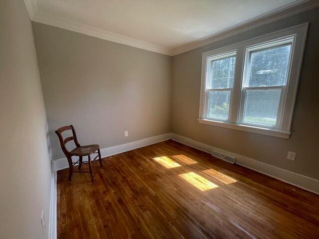 519 Whaley St, Cadillac, MI 49601 - unfurnished room featuring ornamental molding, dark wood-type flooring, and baseboards