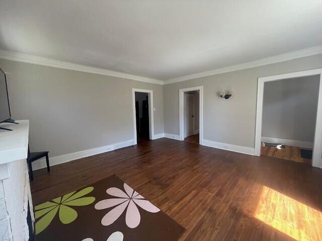519 Whaley St, Cadillac, MI 49601 - unfurnished living room with wood finished floors, ornamental molding, and baseboards