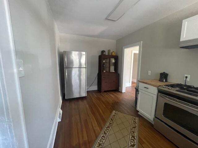 519 Whaley St, Cadillac, MI 49601 - kitchen featuring stainless steel appliances, white cabinetry, dark wood-style flooring, wooden counters, and baseboards