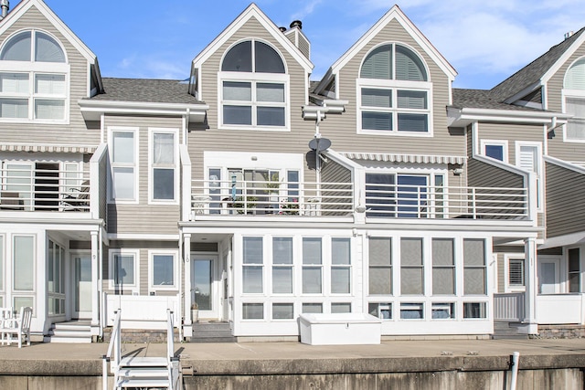 409 Lake Dr Unit 10, New Buffalo, MI 49117 - back of house with a balcony, entry steps, and a shingled roof