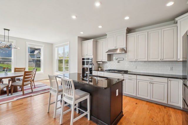 5534 Helmsdale Blvd, West Bloomfield, MI 48322 - kitchen featuring a sink, stainless steel gas cooktop, under cabinet range hood, decorative backsplash, and recessed lighting