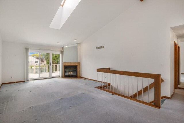 43389 Riverbend Blvd, Clinton Township, MI 48038 - unfurnished living room with carpet floors, lofted ceiling, baseboards, a tiled fireplace, and a skylight