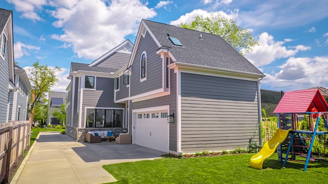 view of side of home with a playground, driveway, a yard, an attached garage, and roof with shingles