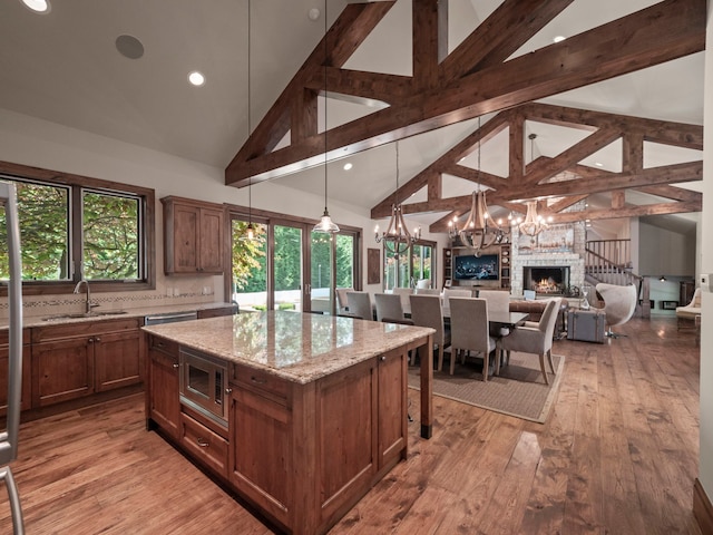 3418 Westchester Rd, Bloomfield Hills, MI 48304 - kitchen featuring a sink, appliances with stainless steel finishes, a chandelier, high vaulted ceiling, and light stone counters