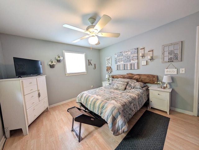 bedroom featuring baseboards, light wood finished floors, and a ceiling fan