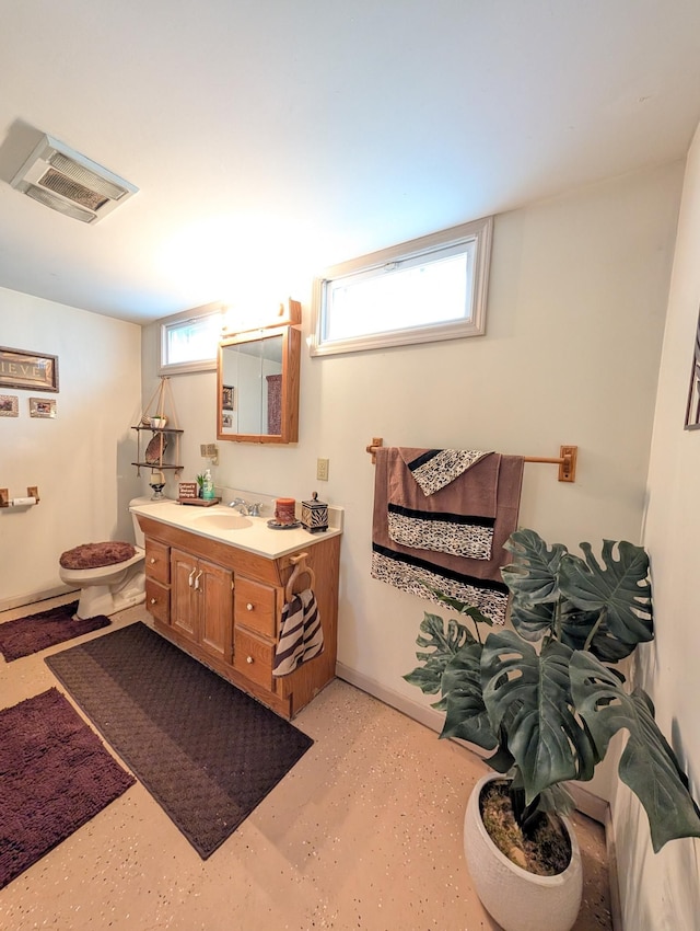 bathroom featuring vanity, toilet, and baseboards