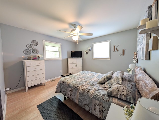 bedroom featuring light wood-type flooring, baseboards, and a ceiling fan