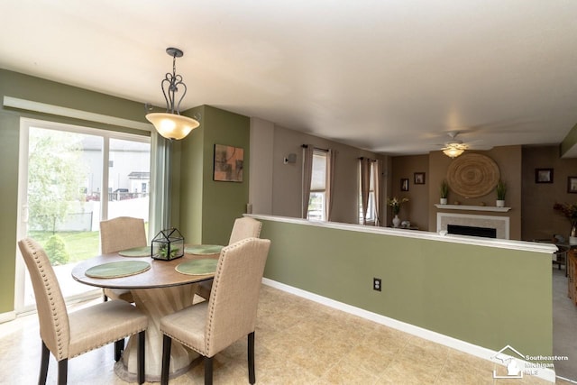 1786 Arbor Creek Dr, Monroe, MI 48162 - dining area featuring a ceiling fan, baseboards, and a fireplace