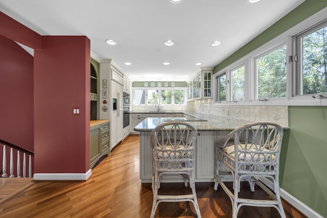 2660 Silverdown Ct, Waterford, MI 48328 - kitchen with a sink, plenty of natural light, light wood-style floors, a peninsula, and recessed lighting