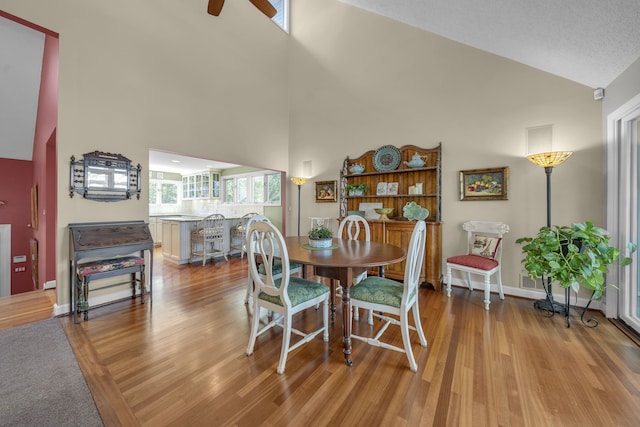 2660 Silverdown Ct, Waterford, MI 48328 - dining space with wood finished floors, high vaulted ceiling, a ceiling fan, and baseboards