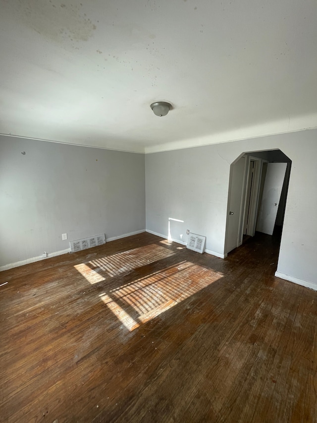11336 Minock St, Detroit, MI 48228 - empty room with baseboards, dark wood-style flooring, and arched walkways
